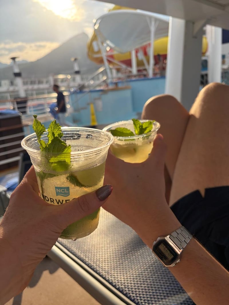 Dos mojitos brindando en la cubierta de un crucero al atardecer
