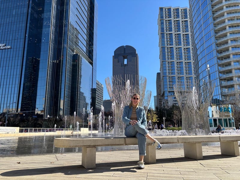 Miriam sentada frente a las fuentes de Klyde Warren Park en Dallas